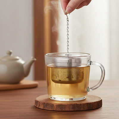 infuseur thé dans tasse en verre sur planche de bois