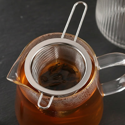 filtre a the infusant the dans pichet sur table brune