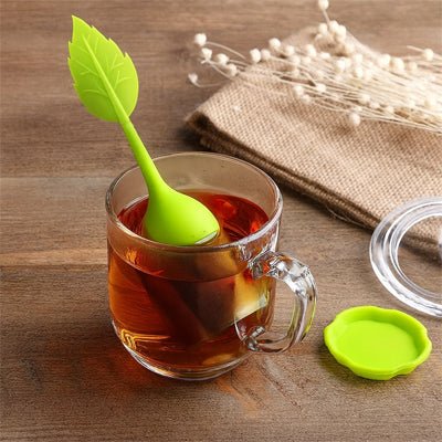 infuseur a the vert dans tasse sur table brune