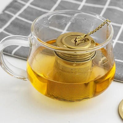 infuseur a the dans tasse en verre