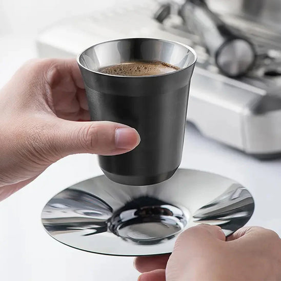 tasse café avec coupelle dans les mains d'un individu